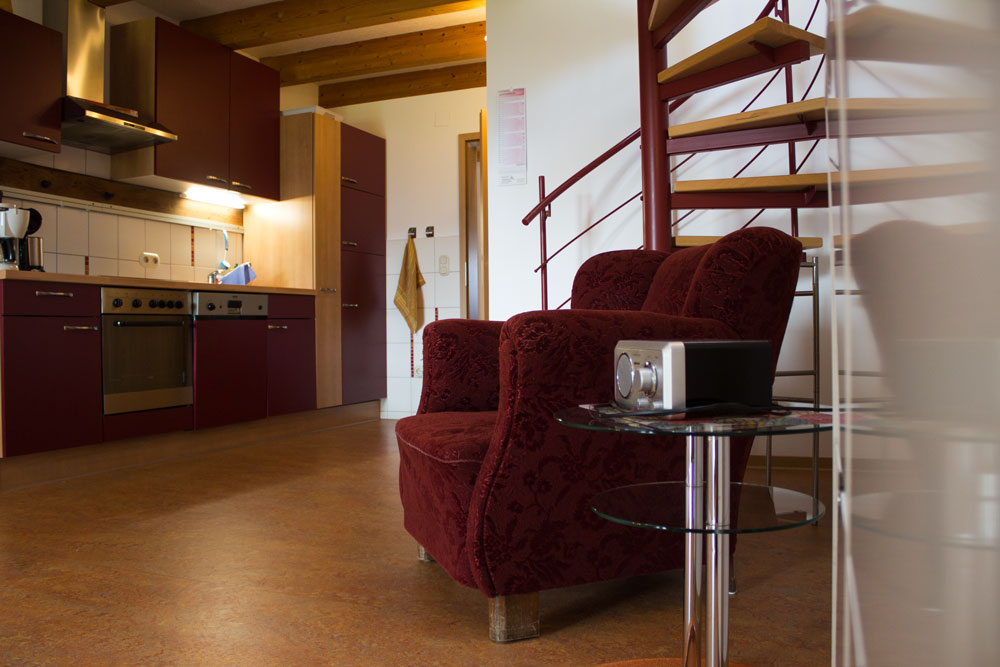 Sessel und Küche linke Wohnung | Ferienwohnung Sonnenhof Weidenhausen